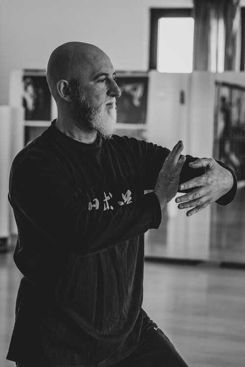 Massimiliano Caporali in una posizione di Tai Chi, foto in bianco e nero